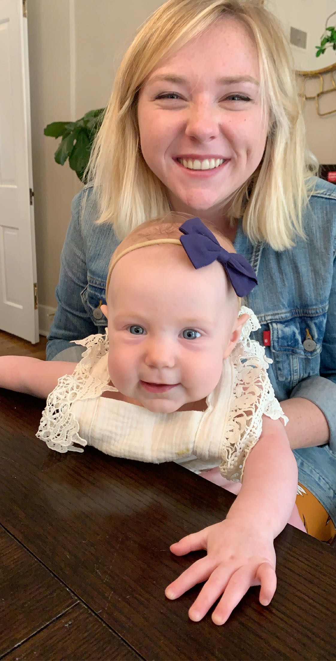 Image of Allison Wiederin smiling holding a baby in her lap